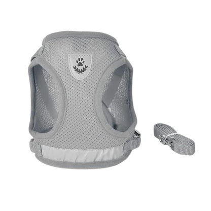 A light gray mesh dog harness with a matching adjustable strap, shown on a plain white background. The harness features a central shield-shaped patch with a dark gray paw print and leaf design.